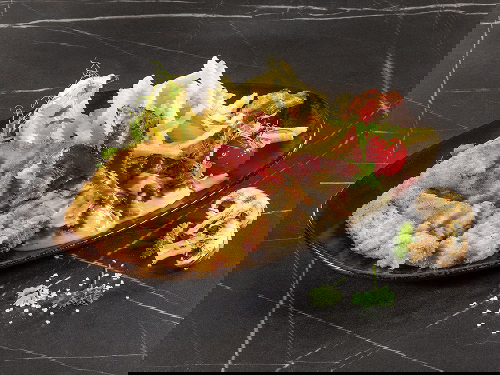 Schnitzel mit Pommes, Champignonrahmsauce und knusprigem Speck.