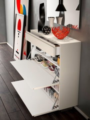 Moderner Hängeschuhschrank mit zwei offenen Klappen, gefüllt mit verschiedenen Schuhen, in einer stilvollen Raumumgebung. Perspektive von schräg oben.