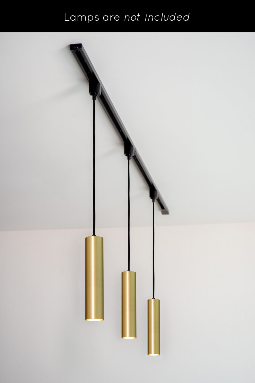 Deckenansicht eines Schienensystems mit drei hängenden, zylinderförmigen, goldfarbenen Lampenfassungen. Lampen sind nicht enthalten.