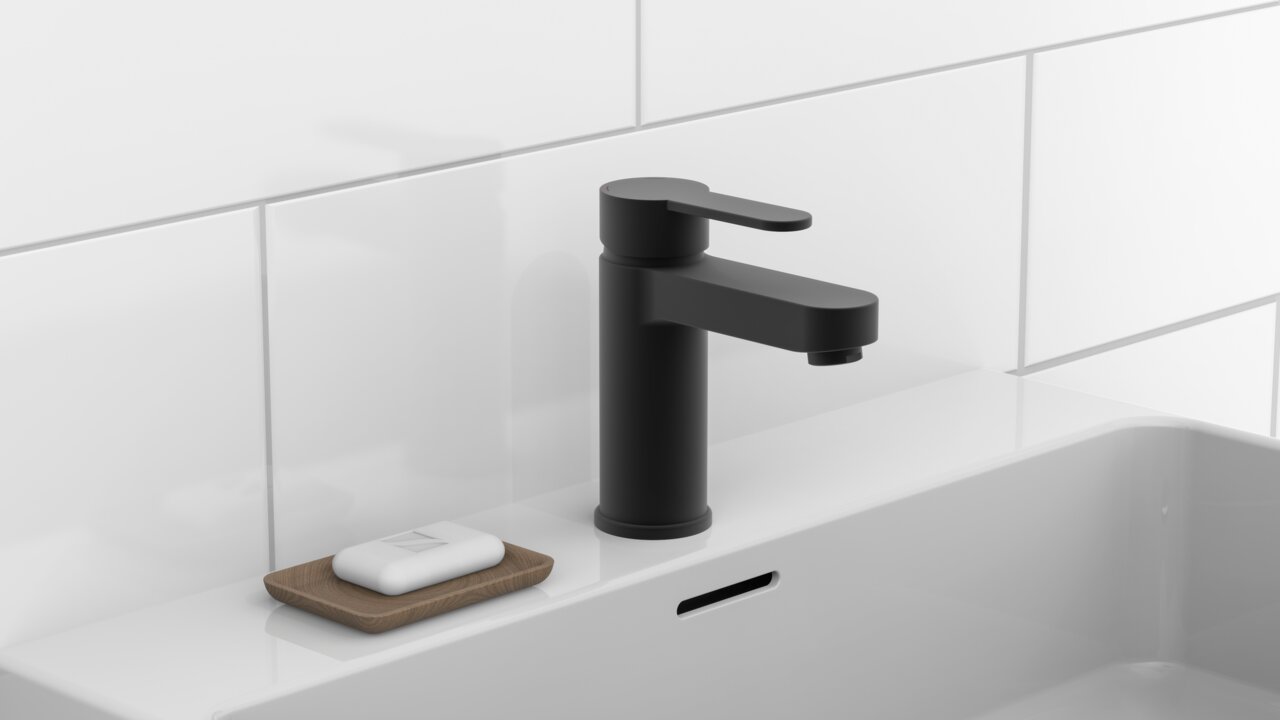 Zwarte wastafelkraan in een modern ontwerp, zijaanzicht, gemonteerd op een witte wastafel met zeepbakje.