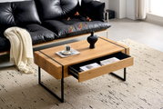 Moderner Couchtisch aus Holz mit schwarzem Metallgestell, Schublade geöffnet, von schräg oben fotografiert, dekoriert mit Vase und Tasse.