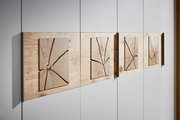 Nahaufnahme eines 6-türigen Drehtürenschranks mit dekorativen Holzelementen auf den Türen, seitliche Perspektive.