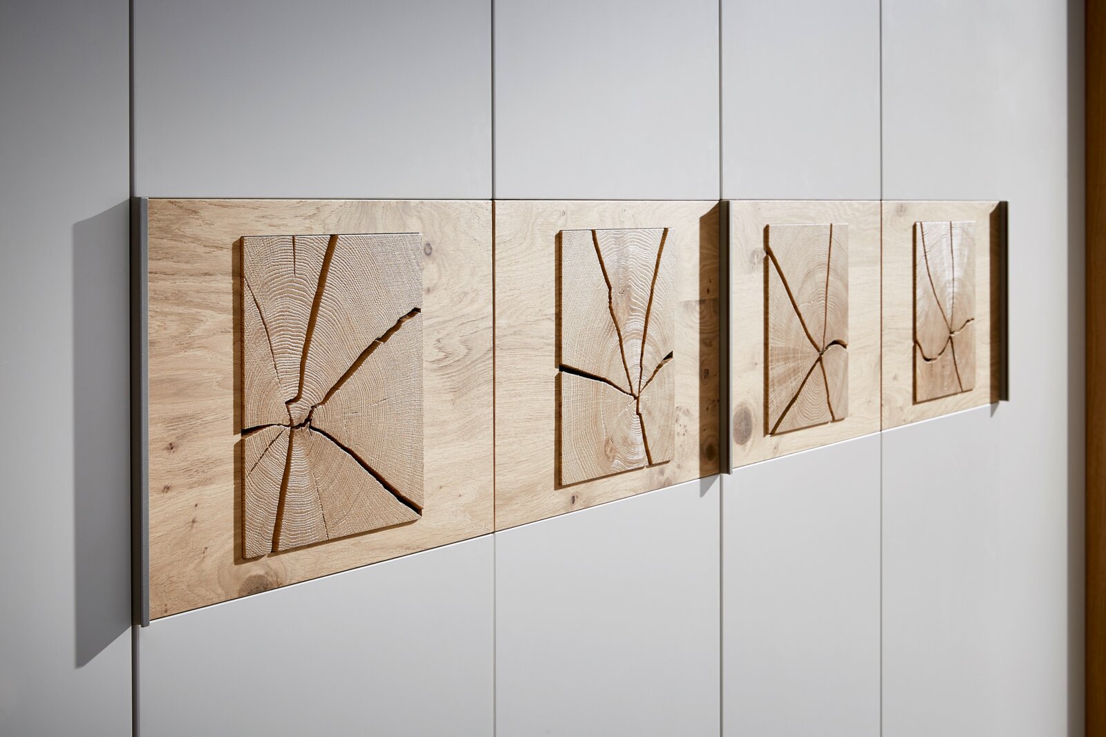 Nahaufnahme eines 6-türigen Drehtürenschranks mit dekorativen Holzelementen auf den Türen, seitliche Perspektive.