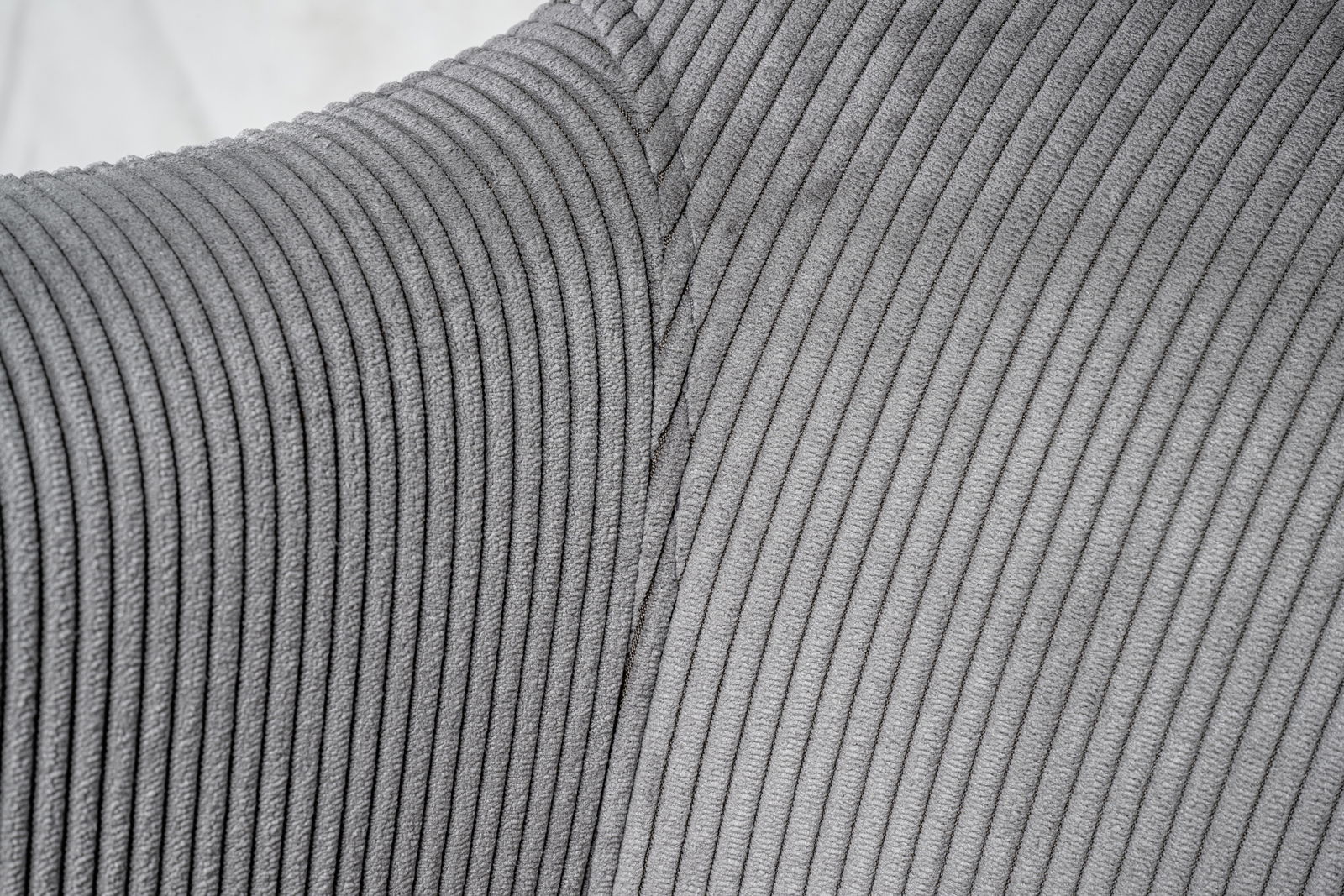 Nahaufnahme eines grauen, gerippten Stoffes eines Drehstuhls, seitliche Perspektive