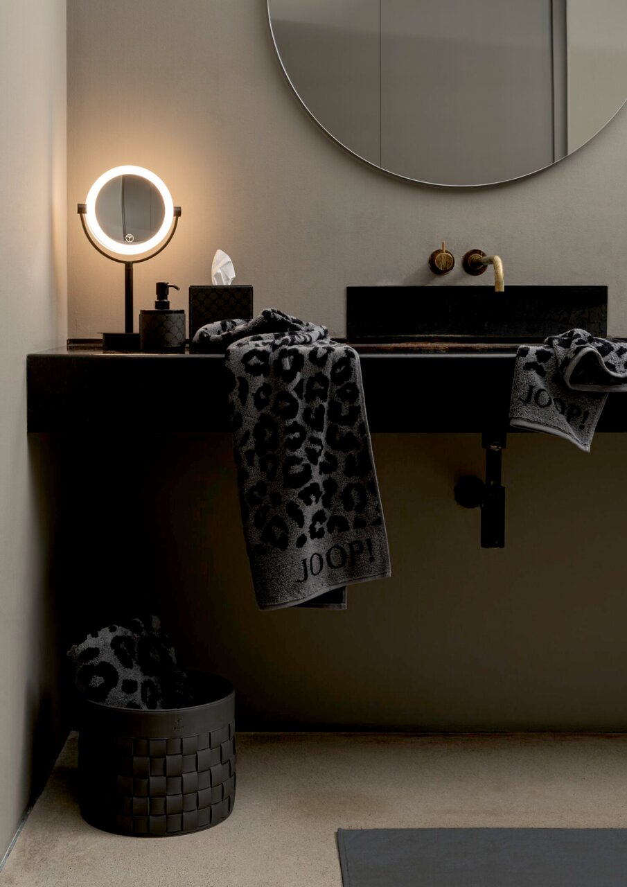 Luxuriöses Handtuch mit Leopardenmuster und JOOP!-Logo, drapiert über einem modernen Waschbecken in einem stilvollen Badezimmer, seitliche Perspektive.