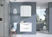 Moderner Badblock mit weißem Waschbeckenunterschrank und Spiegelschrank, frontal fotografiert in einem stilvollen Badezimmer mit blauen Wänden und natürlichem Licht.
