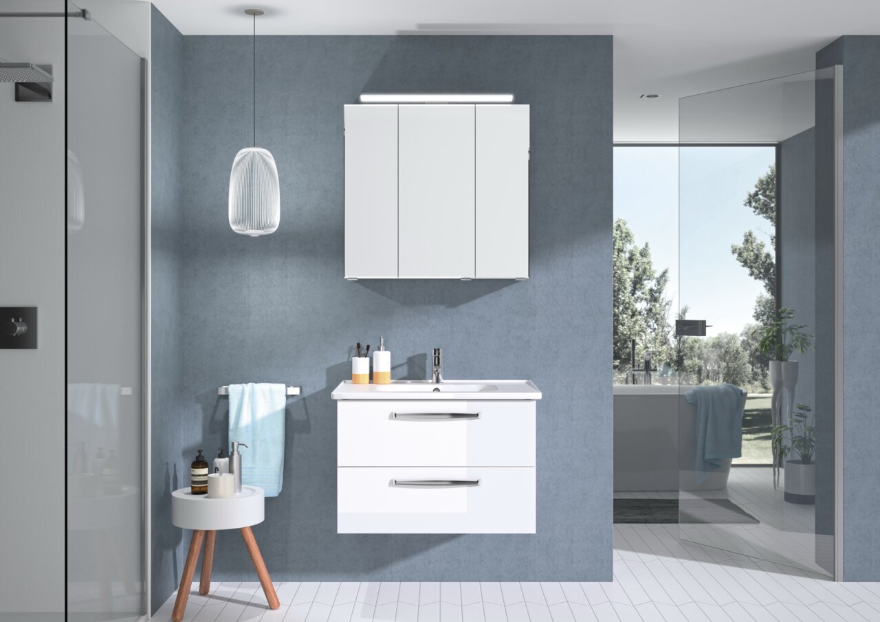 Pelipal Badblock TRENTINO Moderner Badblock mit weißem Waschbeckenunterschrank und Spiegelschrank, frontal fotografiert in einem stilvollen Badezimmer mit blauen Wänden und natürlichem Licht.
