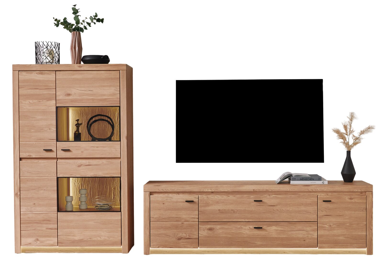 Wohnzimmermöbel aus hellem Holz: hohe Vitrine mit beleuchteten Glasfächern und Sideboard unter einem Fernseher, Frontansicht leicht seitlich auf weißem Hintergrund