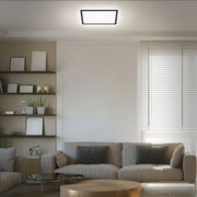 Moderne LED-Deckenleuchte in einem stilvollen Wohnzimmer, von unten betrachtet.