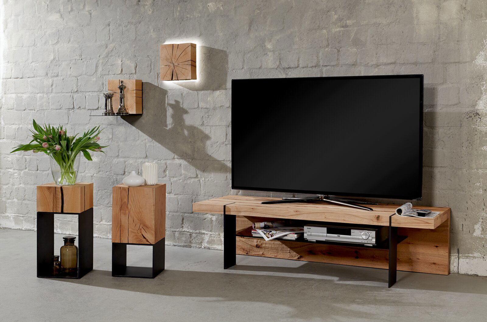 Moderne Wandleuchte aus Holz mit indirekter Beleuchtung, montiert auf einer grauen Ziegelwand, in einem stilvoll eingerichteten Wohnzimmer. Perspektive: Frontalansicht.