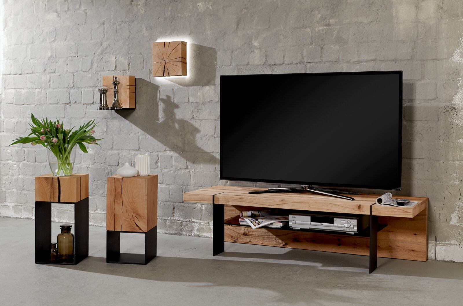 Moderne Wandleuchte aus Holz mit indirekter Beleuchtung, montiert auf einer grauen Ziegelwand, in einem stilvoll eingerichteten Wohnzimmer. Perspektive: Frontalansicht.