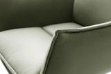 Nahaufnahme eines grünen Sessels mit weicher Polsterung und eleganten Nähten, seitliche Perspektive