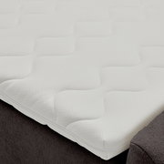 Nahaufnahme eines Boxbetts mit weißem, strukturiertem Topper, seitliche Perspektive