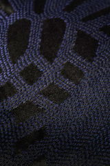 Nahaufnahme einer Zierkissenhülle mit schwarzem und blauem geometrischem Muster.