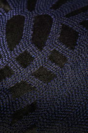 Nahaufnahme einer Zierkissenhülle mit schwarzem und blauem geometrischem Muster.