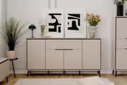 Modernes Sideboard in hellem Beige mit schwarzen Beinen, dekoriert mit Pflanzen und abstrakten Kunstwerken, Frontalansicht.