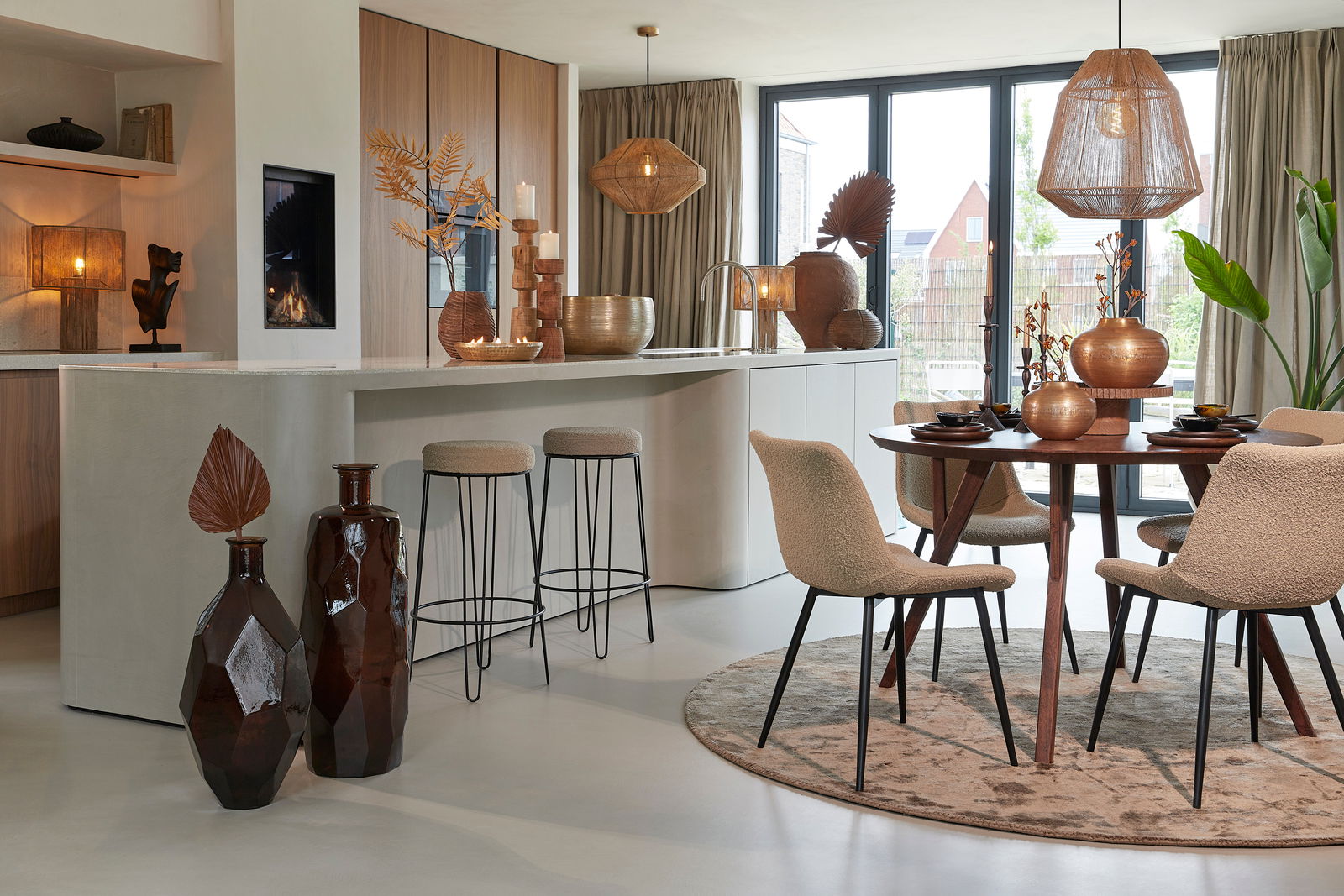 Moderner Esstisch QUENZA aus Holz, rund, mit vier Stühlen in einem stilvoll eingerichteten Esszimmer, seitliche Perspektive.