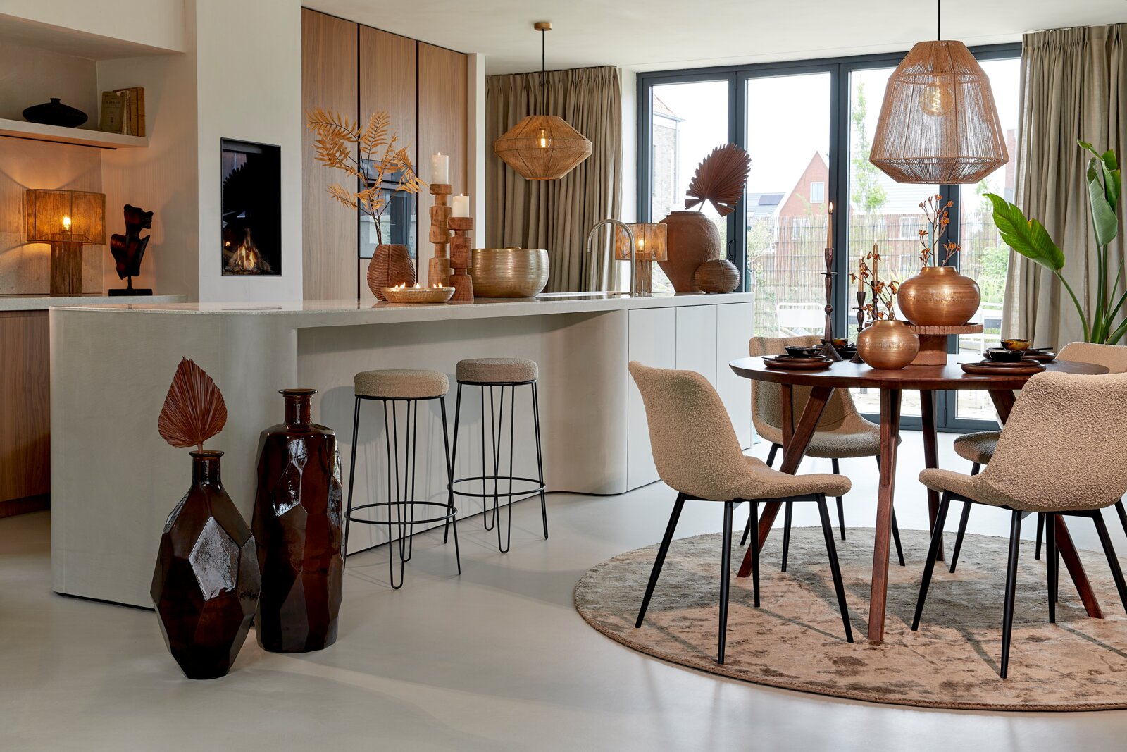 Moderner Esstisch QUENZA aus Holz, rund, mit vier Stühlen in einem stilvoll eingerichteten Esszimmer, seitliche Perspektive.