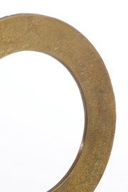 Nahaufnahme eines goldfarbenen, strukturierten Ornaments in Kreisform, seitliche Perspektive