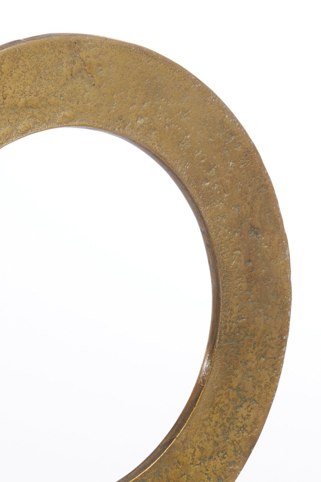 Close-up van een goudkleurig, gestructureerd ornament in de vorm van een cirkel, gezien vanuit de zijkant