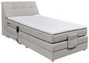 Boxspringbett in hellem Stoffbezug mit verstellbarem Kopfteil und Fernbedienung, seitliche Perspektive