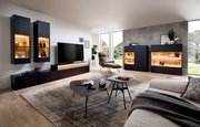 Modernes Wohnzimmer mit stilvollem Highboard in dunklem Design, seitliche Perspektive.