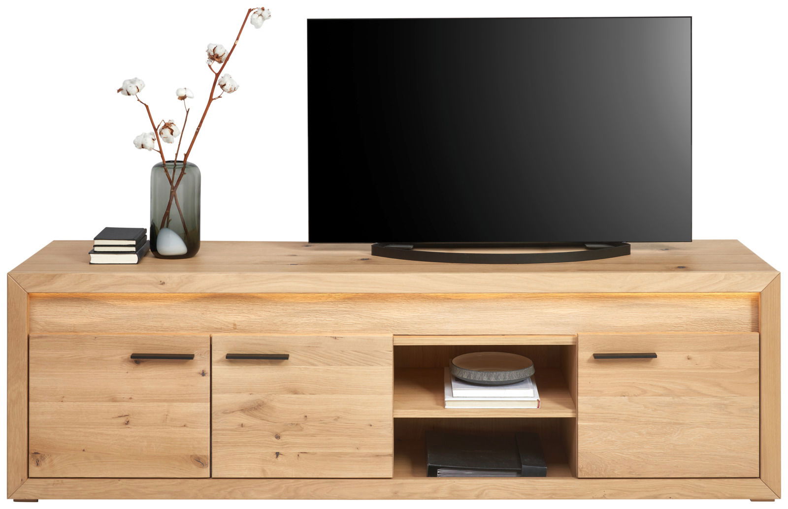 Frontale Ansicht eines TV-Lowboards aus Holz mit zwei Schubladen, einem offenen Fach mit Büchern und Dekoration, sowie einem Fernseher darauf.