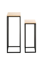 Zwei schmale Beistelltische/Säulen mit hellen Holzplatten und schwarzem Metallgestell in unterschiedlichen Höhen, frontale Ansicht leicht von oben vor weißem Hintergrund.