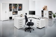 Moderner schwarzer Drehstuhl mit ergonomischer Rückenlehne und Kopfstütze, seitliche Perspektive in einem hellen Büro mit weißen Möbeln.
