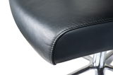 Nahaufnahme eines schwarzen Ledersitzes eines Chefsessels mit verchromtem Fußgestell, seitliche Perspektive.