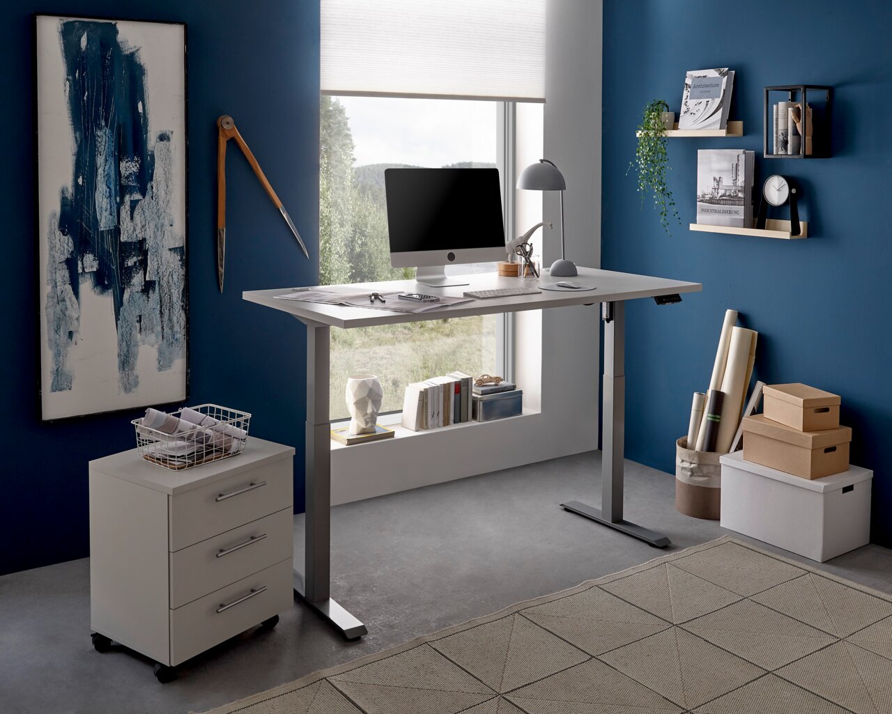 Moderner höhenverstellbarer E-Schreibtisch in einem stilvollen Büro mit blauer Wand, seitlicher Perspektive.