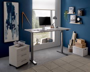 Moderner höhenverstellbarer E-Schreibtisch in einem stilvollen Büro mit blauer Wand, seitlicher Perspektive.