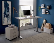 Moderner höhenverstellbarer E-Schreibtisch in einem stilvollen Büro mit blauer Wand, seitlicher Perspektive.