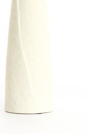 Nahaufnahme einer strukturierten, cremefarbenen Vase mit minimalistischem Design.