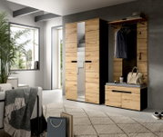 Moderne Garderoben-Kombination aus Holzoptik mit Kleiderschrank inklusive mittigem Spiegel und Sitzbank mit Kleiderhaken und Ablage, gezeigt in leichter Frontansicht im Wohnraum.