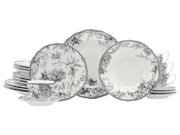 Schwarz-weißes Porzellan-Geschirrset mit floralen Motiven und Vogelillustration, bestehend aus Tellern, Schalen und Tassen, frontal in leicht schräger Perspektive auf weißem Hintergrund präsentiert.