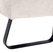 Nahaufnahme der unteren Ecke einer Sitzbank mit cremefarbenem Stoffbezug und schwarzem Metallgestell, seitliche Perspektive.