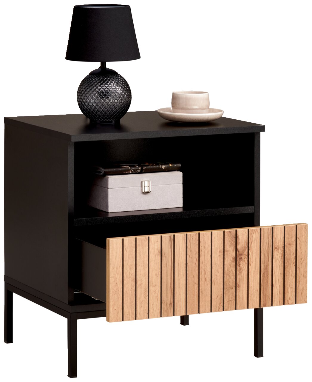 Schwarze Nachtkommode mit offener Schublade aus Holzlamellen, darauf eine schwarze Lampe und eine Tasse, seitliche Perspektive