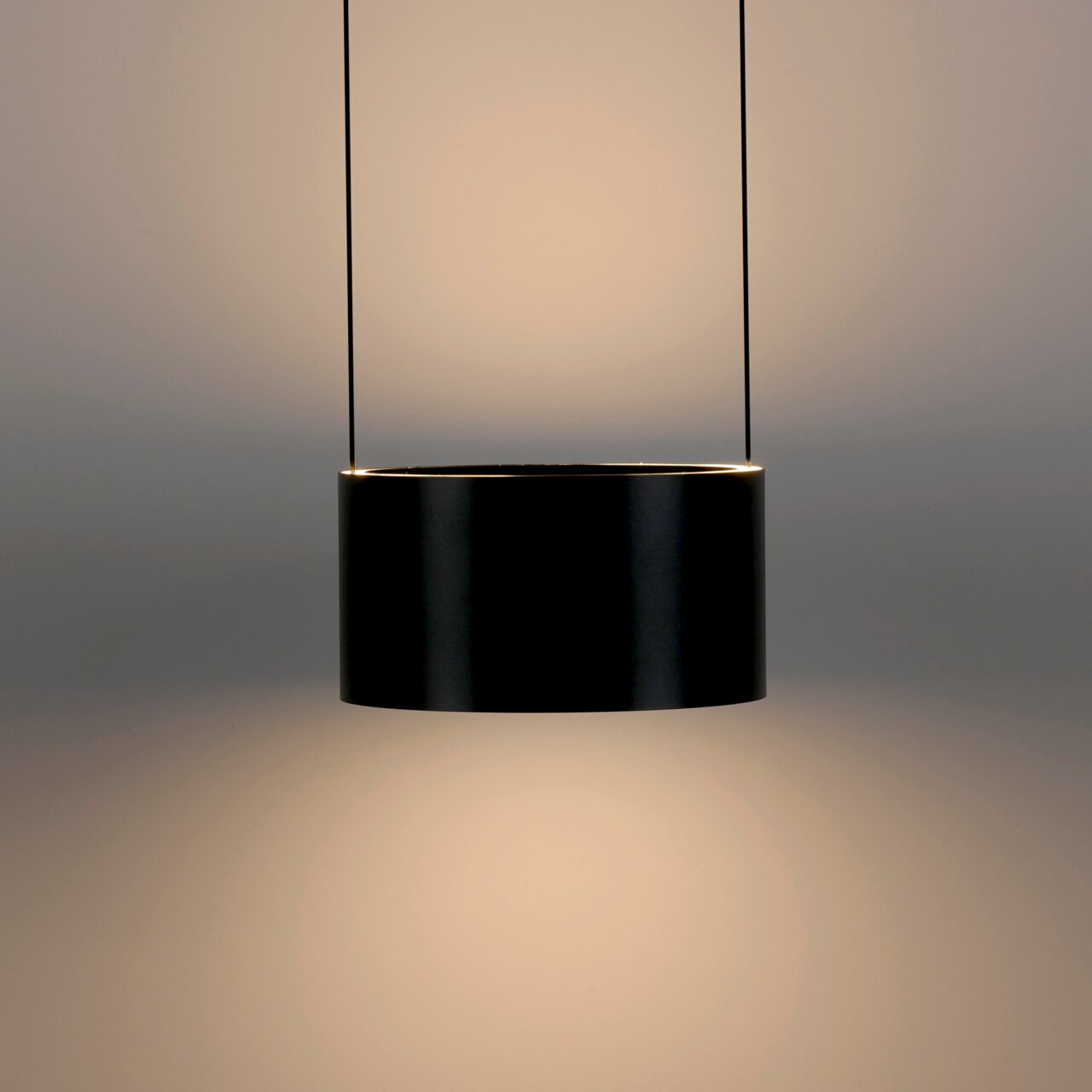 Moderne schwarze LED-Pendelleuchte in zylindrischer Form, seitliche Perspektive