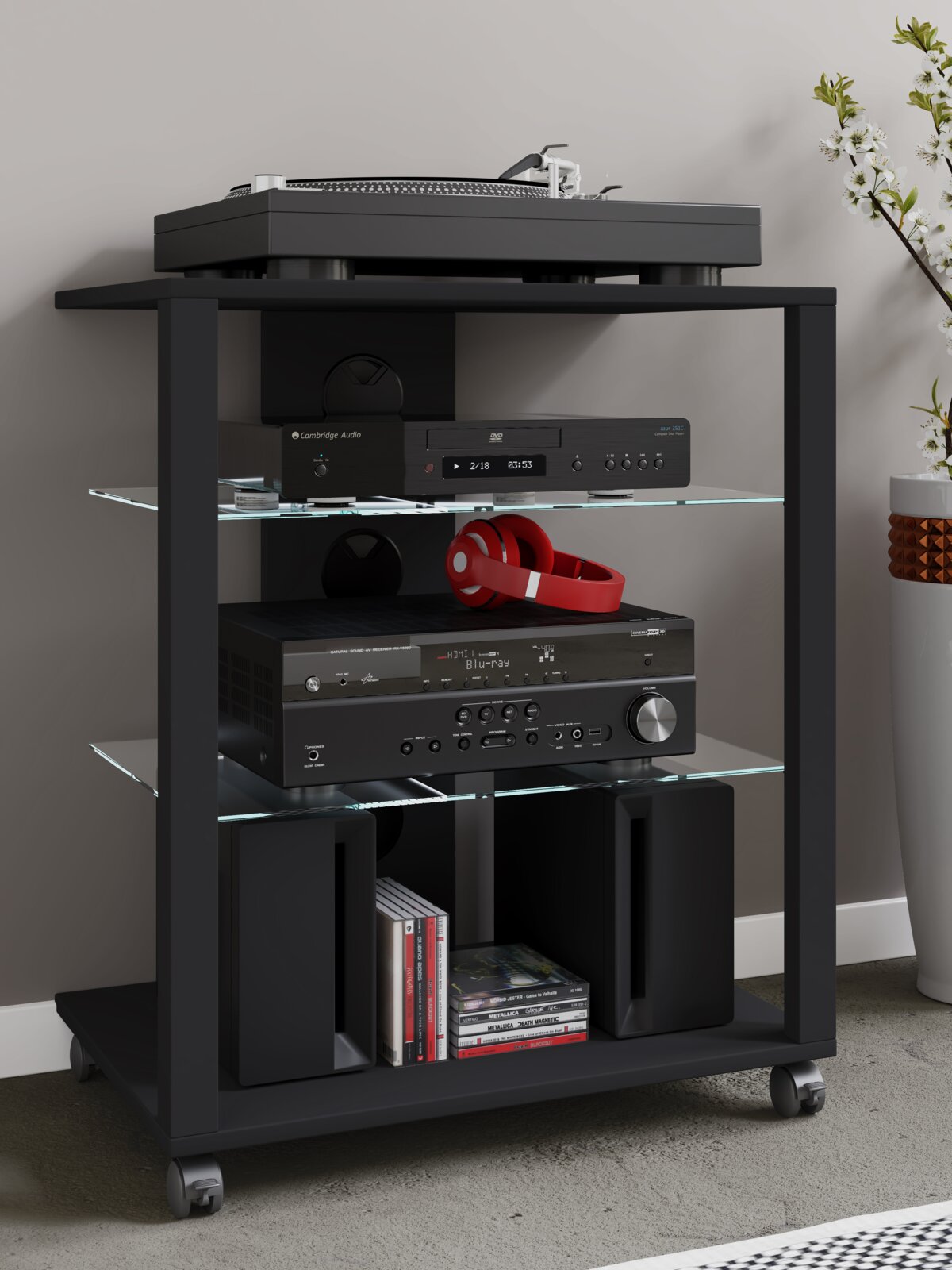 Schwarzes HiFi-Rack auf Rollen mit Glasböden, bestückt mit Plattenspieler, Verstärker/Receiver, Kopfhörer und Lautsprechern, in seitlicher Vorderansicht.