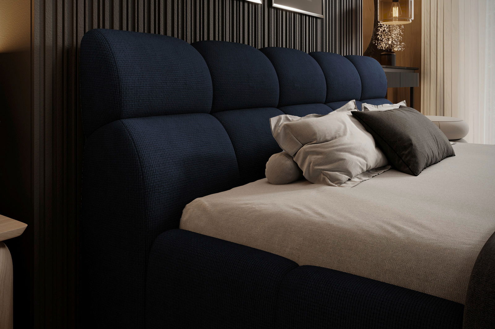 Seitliche Perspektive auf ein elegantes Polsterbett mit dunkelblauem Kopfteil und mehreren Kissen.