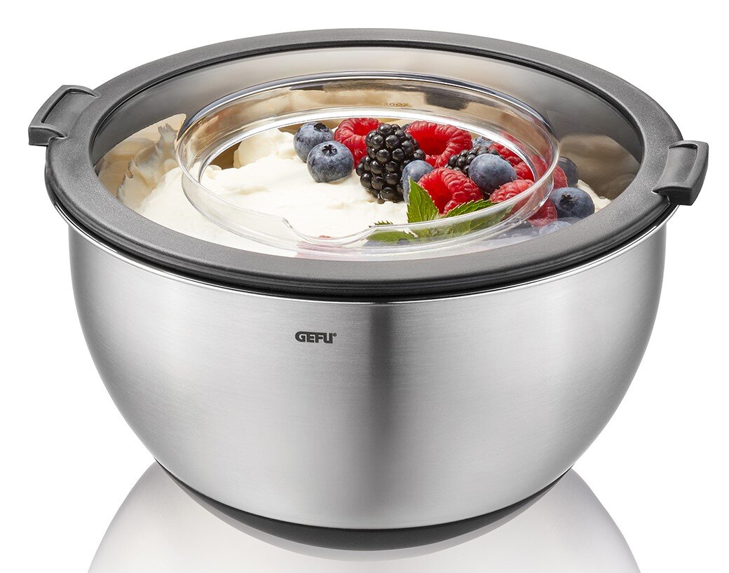 Edelstahl-Schüssel mit Spritzschutzdeckel, gefüllt mit Sahne und Beeren, aus der Vorderansicht