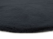 Nahaufnahme eines dunkelgrauen Fellteppichs mit weicher, flauschiger Textur.