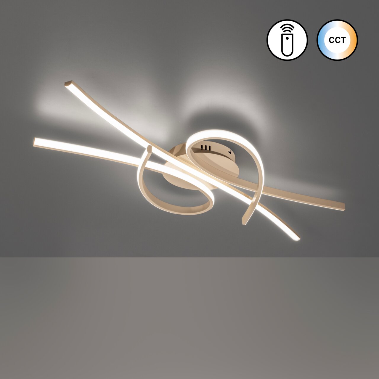 Moderne led-plafondlamp met een gebogen vormgeving, voorzien van warmwitte lichtstroken en een CCT-functie; gezien van onderaf in een licht schuin perspectief, gemonteerd aan het plafond.