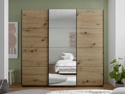 Großer Kleiderschrank mit Schiebetüren in heller Holzoptik und mittiger Spiegeltür, frontal aus Augenhöhe im Schlafzimmer fotografiert.