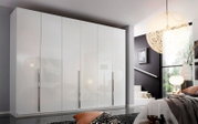 Moderner, weißer 6-türiger Drehtürenschrank in einem stilvollen Schlafzimmer, frontal betrachtet.