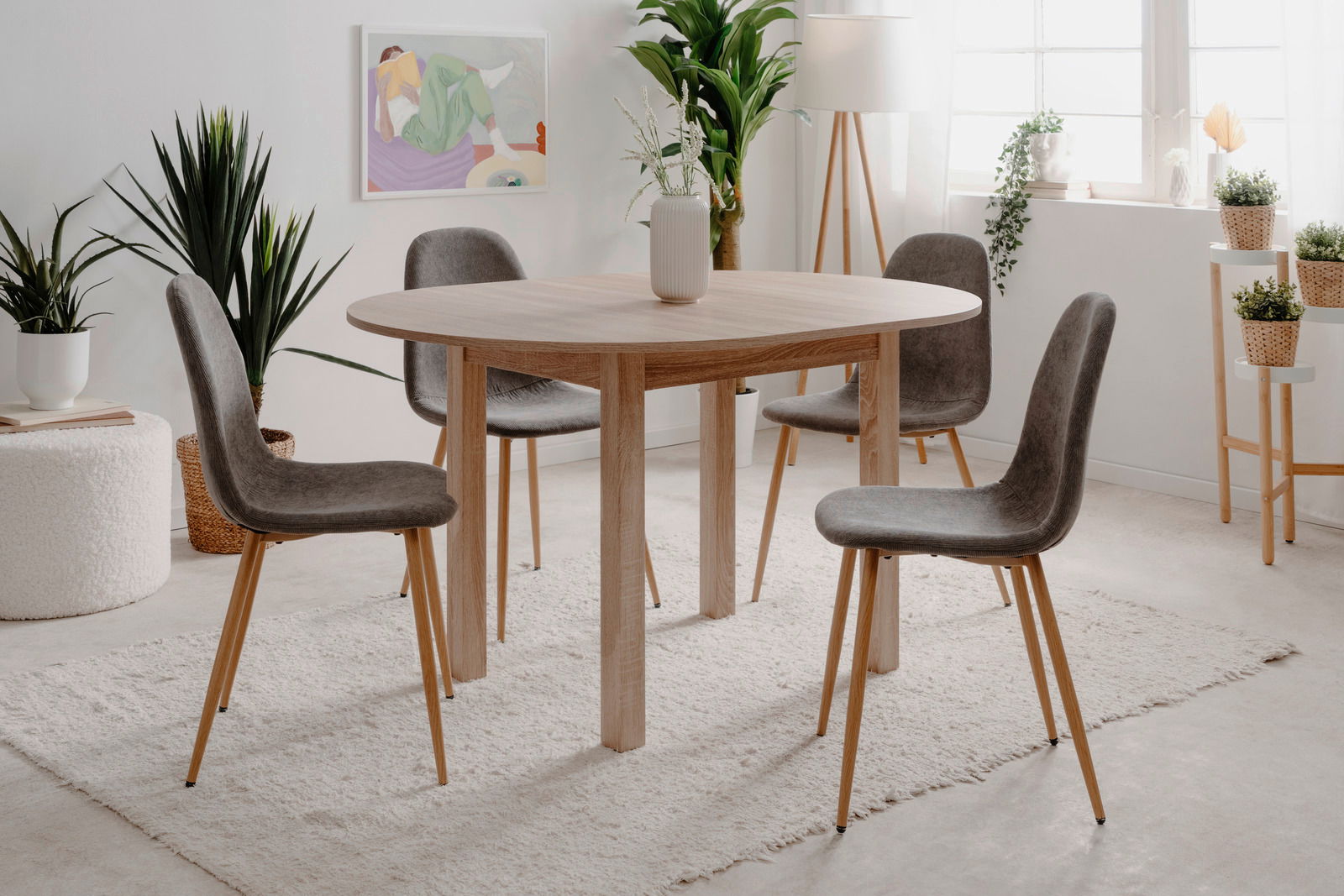 Runder Esstisch aus Holz mit vier grauen Stühlen in einem hellen, modernen Raum, seitliche Perspektive.