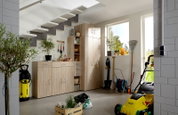 Gartenhaus mit Holzschränken, Gartengeräten und Pflanzen, seitliche Perspektive