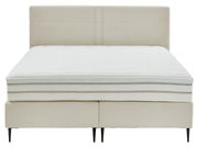 Frontale Ansicht eines eleganten Boxspringbetts mit gestepptem Kopfteil und schlanken schwarzen Beinen.