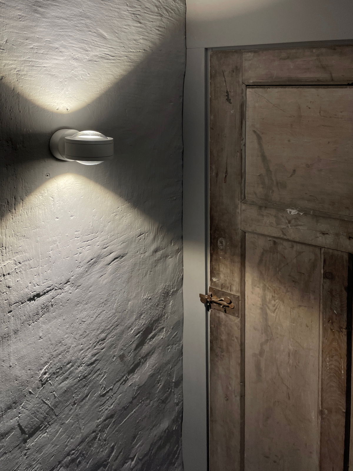 LED Wandleuchte an einer Wand montiert, die ein warmes Licht nach oben und unten abstrahlt, seitliche Perspektive